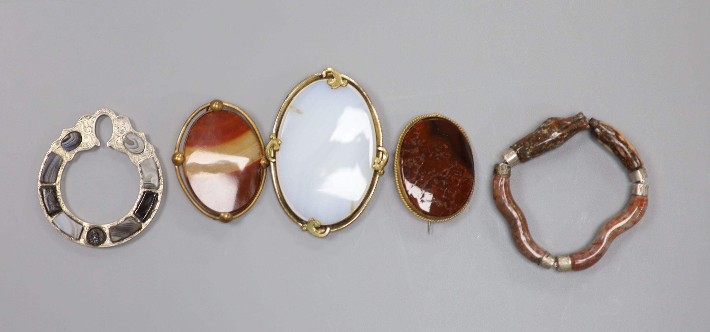 Four assorted base metal and chalcedony set brooches and a white metal and hardstone set serpent bracelet (a.f.).